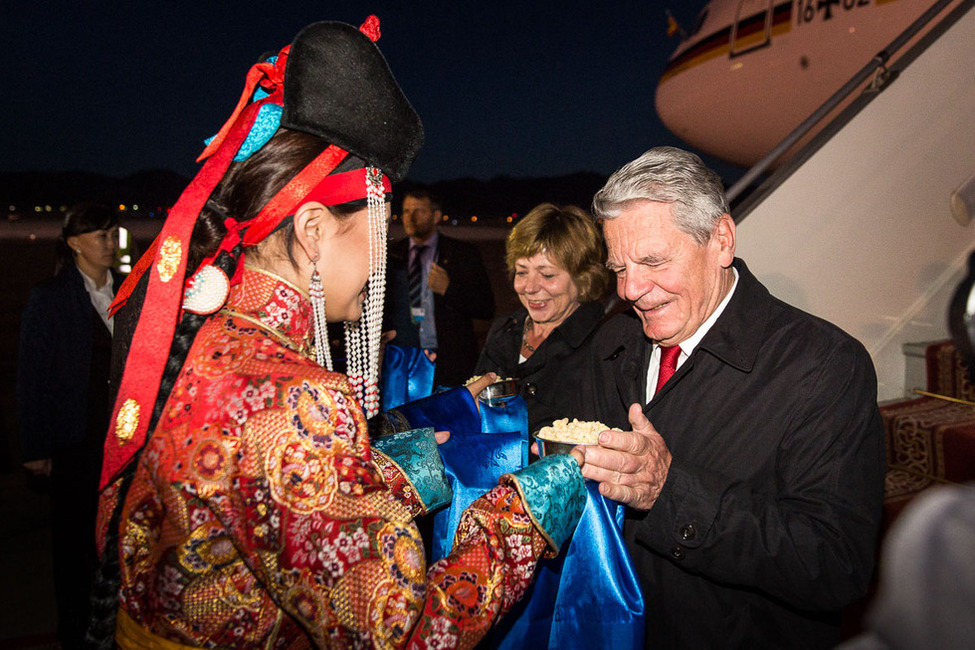 Federal President Joachim Gauck and his partner Daniela Schadt receive a silver bowl of dry curd as a welcome gift upon their arrival at the airport Chinggis Khaan in Ulan Bator on the occasion of the state visit to Mongolia