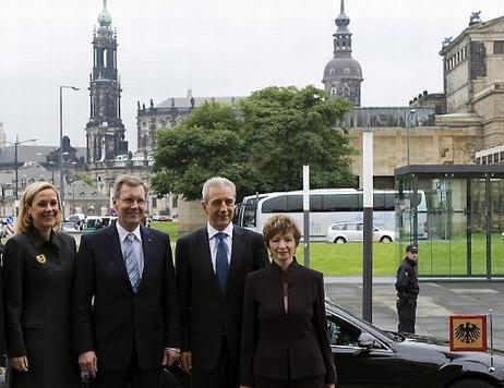 Ehepaare Wulff und Tillich in Dresden vor einem Dienstwagen mit der Standarte des Bundespräsidenten und der Kathedrale St. Trinitatis 