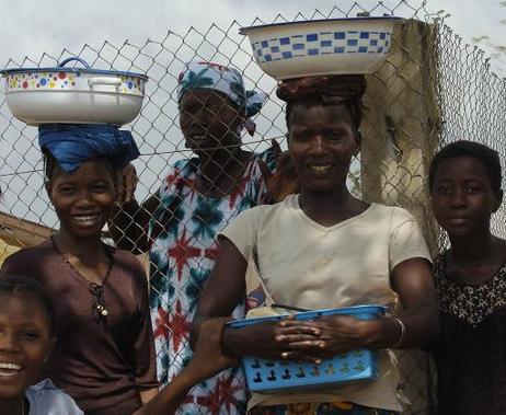 Frauen in Sierra Leone, die Schüsseln auf dem Kopf tragen