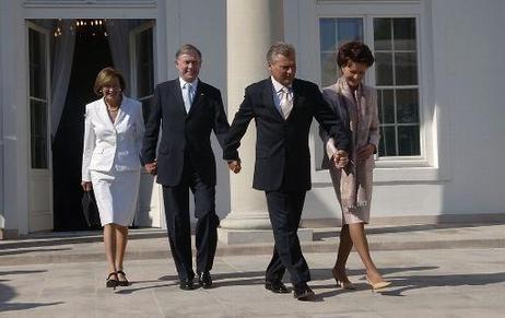 Der Bundespräsident und seine Frau und Präsident Kwasniewski und seine Frau fassen sich an den Händen.