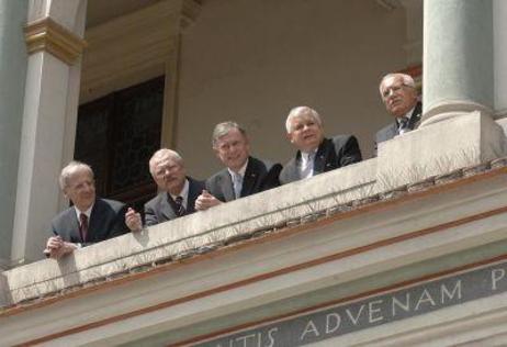 Die fünf Präsidenten beugen sich über eine Balkonbrüstung.