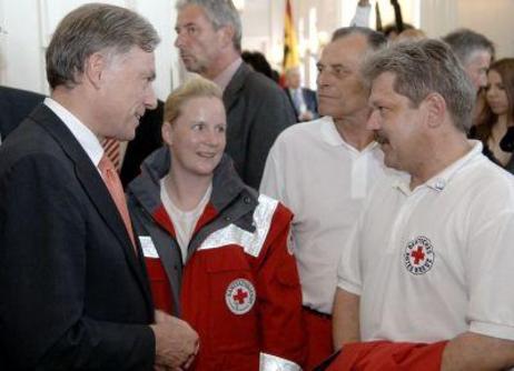Bundespräsident Horst Köhler unterhält sich mit Helfern in Rot-Kreuz-Uniformen