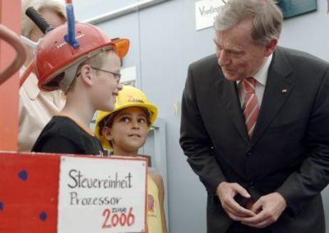Bundespräsident Horst Köhler unterhält sich mit Kindern, die Schutzhelme tragen.