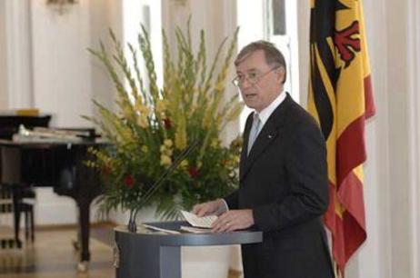 Bundespräsident Horst Köhler am Rednerpult, daneben die Standarte und Blumen