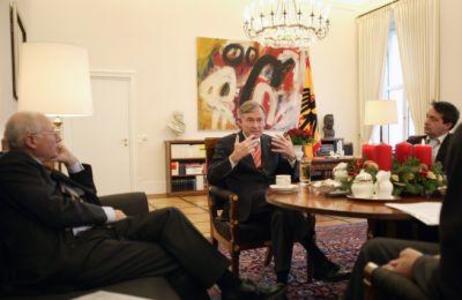 Bundespräsident Horst Köhler sitzt mit Stefan Aust und Gabor Steingart am Besuchertisch in seinem Amtszimmer; auf dem Tisch ein Adventskranz. 