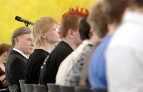 Bundespräsident Horst Köhler sitzt neben Schülern im Publikum und hört zu.