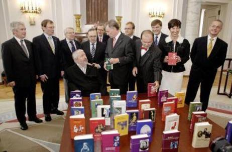 Bundespräsident Horst Köhler und Gäste hinter einem Tisch mit aufgestellten Büchern in verschiedenfarbigen Einbänden