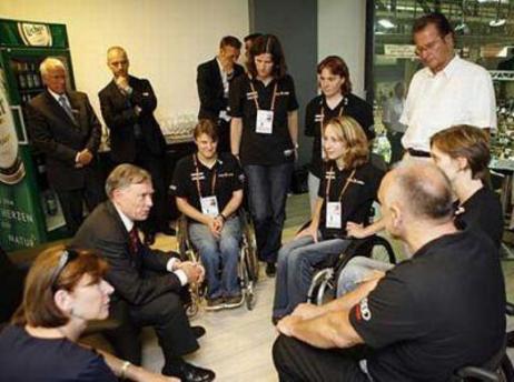 Der Bundespräsident und Frau Köhler sitzen in einem Kreis mit Rollstuhlfahrerinnen