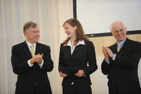 Bundespräsident Horst Köhler steht neben einer Schülerin und einem grauhaarigen Herrn auf der Bühne und klatscht