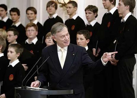 Der Bundespräsident am Rednerpult. Im Hintergrund steht der Chor.