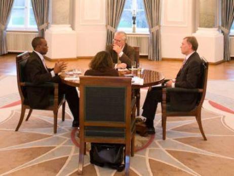 Bundespräsident Horst Köhler sitzt mit drei Personen um einen Tisch