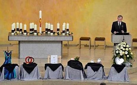 Bundespräsident Horst Köhler am Rednerpult in der Kirche vor gelbem Hintergrund, daneben der Altar mit 15 Kerzen, vor ihm die Symbole der Schüler