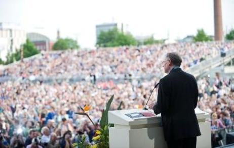 Bundespräsident Horst Köhler steht auf der Bühne im Freien, davor tausende von Menschen 