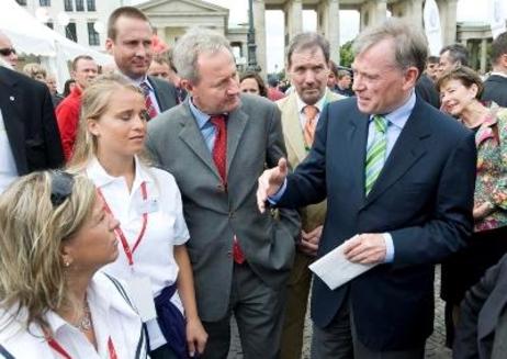 Der Bundespräsident im Gespräch mit zwei Sportlerinnen in weißen Trikots