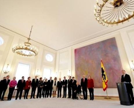 Gruppenbild: Die Mitglieder der Bundesregierung stehen im Halbkreis, der Bundespräsident am Rednerpult