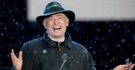 Der Bundespräsident steht mit Hut und Mantel im Schnee an einem Mikrofon. 