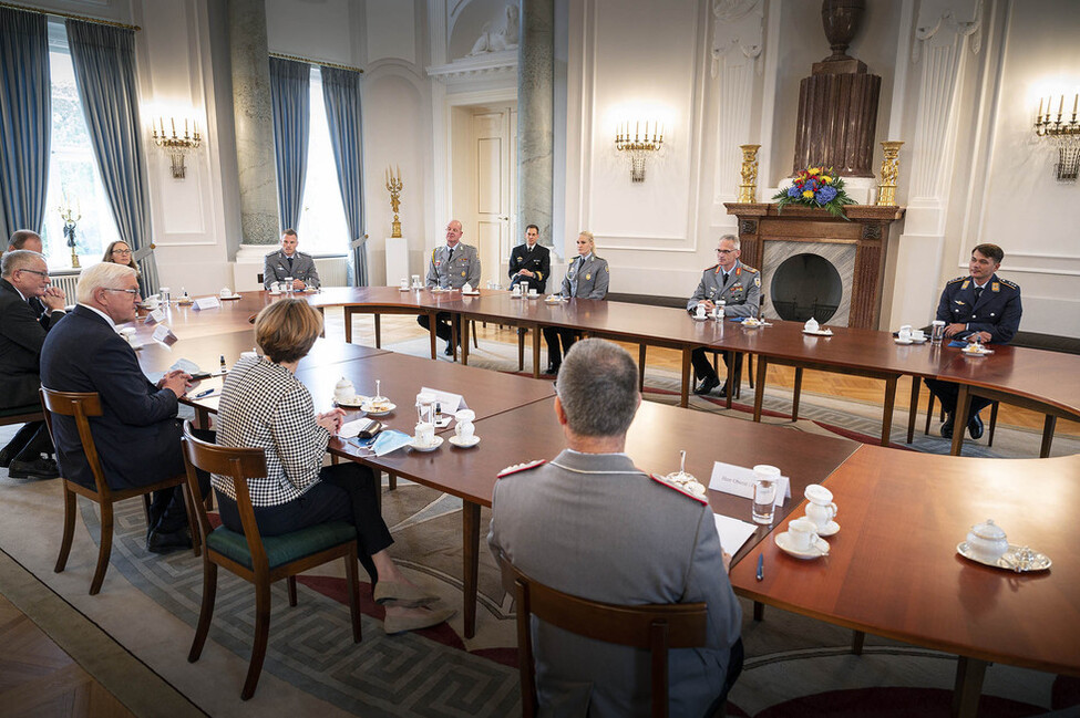 Bundespräsident Frank-Walter Steinmeier und Elke Büdenbender sitzen mit Brigadegeneral Jens Arlt und an der militärischen Evakuierungsoperation in Kabul und Taschkent beteiligten Soldatinnen und Soldaten an einem Tisch im Langhanssaal von Schloss Bellevue