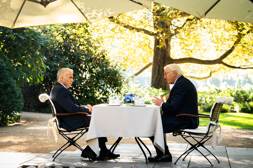 Bundespräsident Frank-Walter Steinmeier im Austausch mit dem Ministerpräsidenten des Staates Israel, Yair Lapid, im Schlosspark von Schloss Bellevue