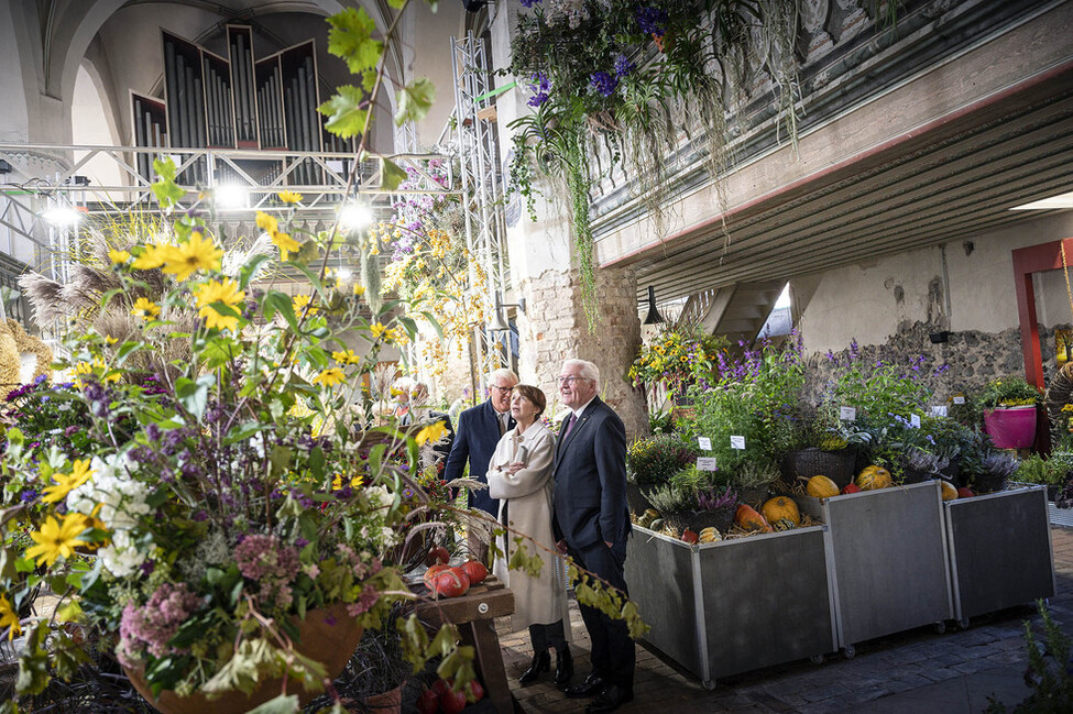 Bundespräsident Frank-Walter Steinmeier, Elke Büdenbender und der Bürgermeister der Stadt Beelitz, Bernhard Knuth, beim Rundgang durch die Blumenhallenschau zum Thema Erntedank in der Stadtpfarrkirche St. Marien-St. Nicolai in Beelitz