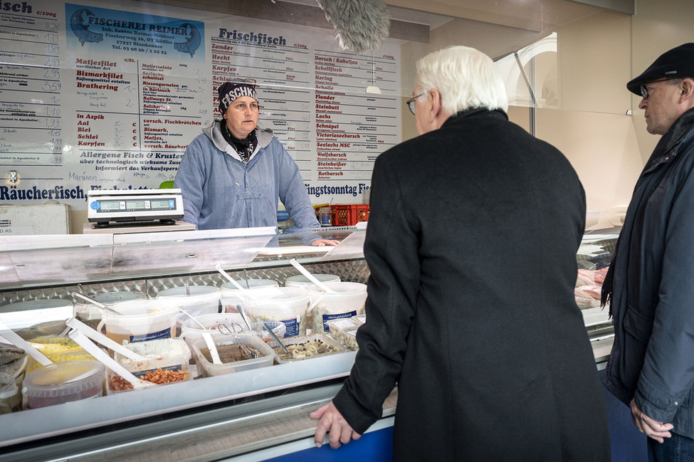 Bundespräsident Frank-Walter Steinmeier und Bürgermeister Andreas Grund im Austausch mit einer Verkäuferin auf dem Markt in Neustrelitz