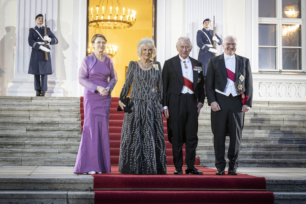 Bundespräsident Steinmeier, König Charles III, die Königin-Gemahlin und Elke Büdenbender stehen in Abendgarderobe auf der Treppe von Schloss Bellevue.