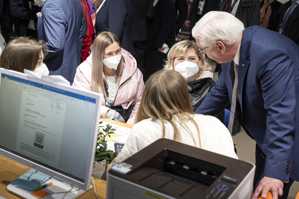 Bundespräsident Steinmeier spricht mit Geflüchteten.