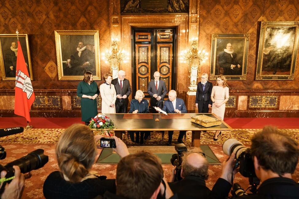 König Charles III. und Königin-Gemahlin Camilla tragen sich ins Goldene Buch im Hamburger Rathaus ein.