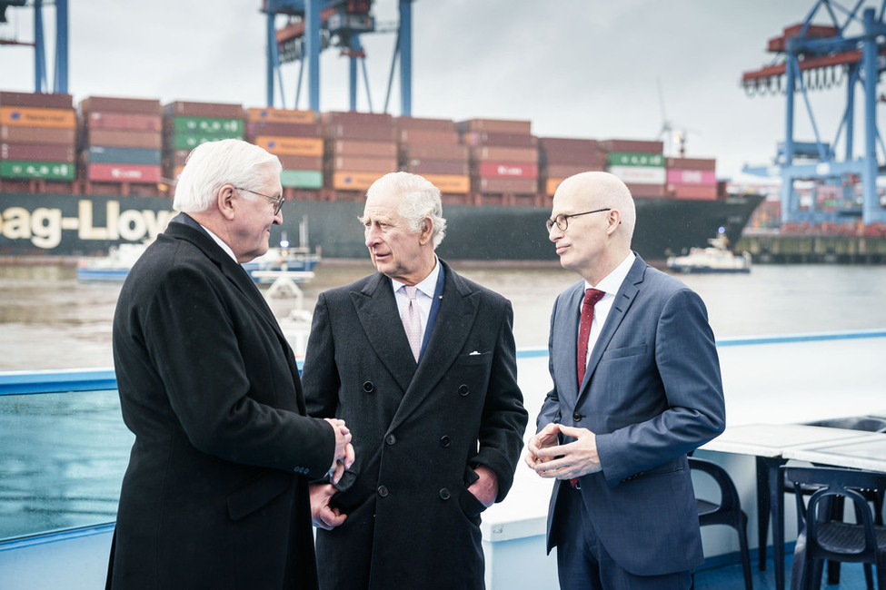 König Charles III. und Bundespräsident Steinmeier zusammen mit Hamburgs Bürgermeister Peter Tschentscher auf dem Deck eines Bootes am Hamburger Hafen.
