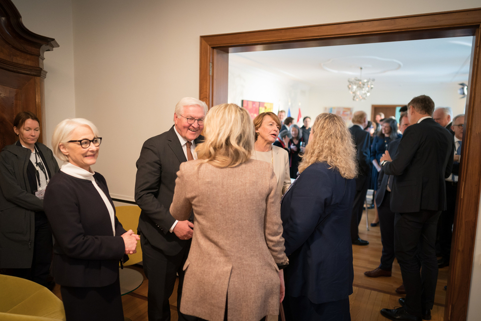 Bundespräsident Steinmeier und Elke Büdenbender stehen gemeinsam mit der deutschen Botschafterin in Ottawa, Sabine Sparwasser, in einer Runde beisammen und unterhalten sich.
