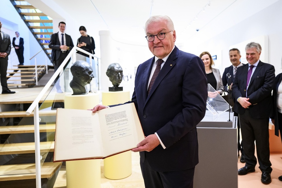 Bundespräsident Steinmeier hält im Stuttgarter Theodor-Heuss-Haus das Original des Heuss’schen Exemplars des Grundgesetzes in der Hand