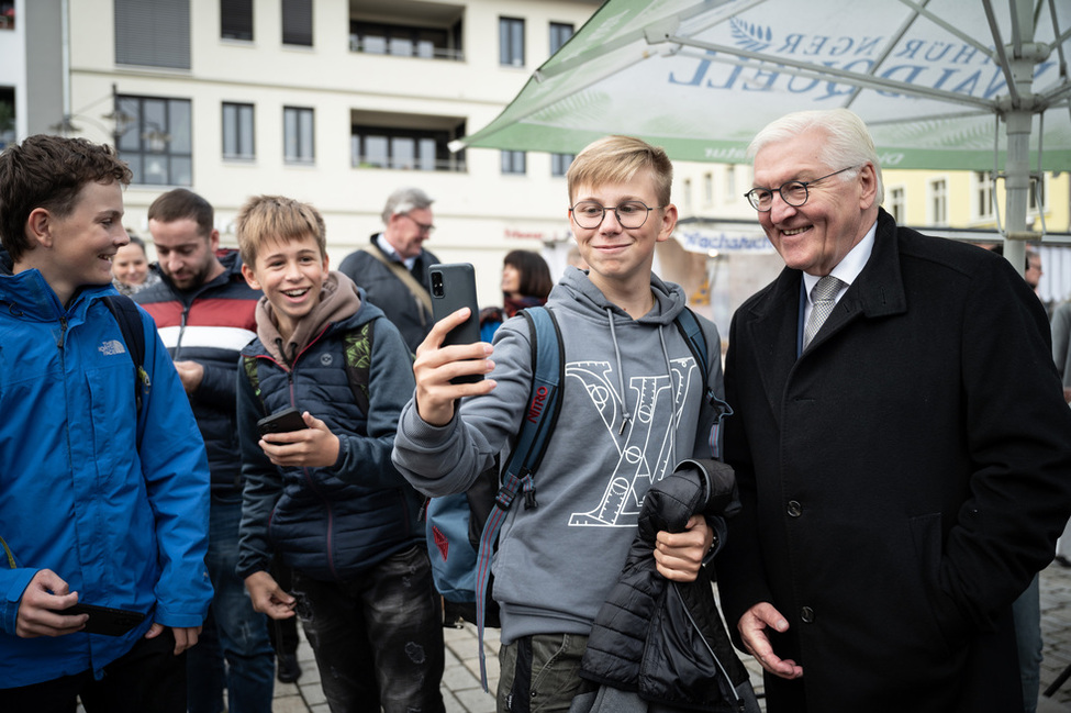 Bundespräsident Frank-Walter Steinmeier macht gemeinsam mit einem Jugendlichen ein Selfie auf dem Marktplatz in Meiningen 
