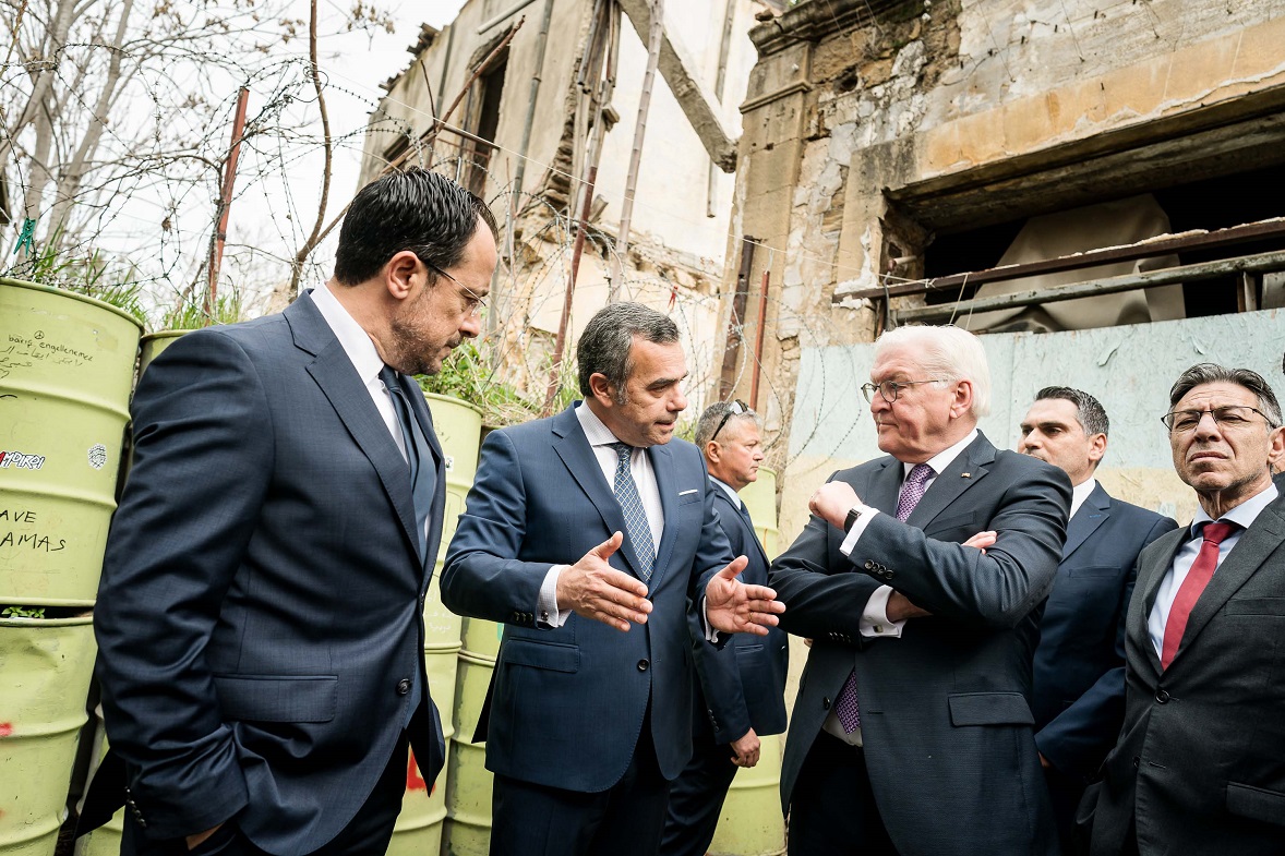 Bundespräsident Steinmeier steht gemeinsam mit dem zyprischen Präsidenten Nikos Christodoulides sowie dem Bürgermeister der Stadt Nikosia, Constantinos Yiorkadijs, vor dem Grenzzaun (© Bundesregierung/Jesco Denzel) Bundespräsident Steinmeier steht gemeinsam mit dem zyprischen Präsidenten Nikos Christodoulides sowie dem Bürgermeister der Stadt Nikosia, Constantinos Yiorkadijs, vor dem Grenzzaun