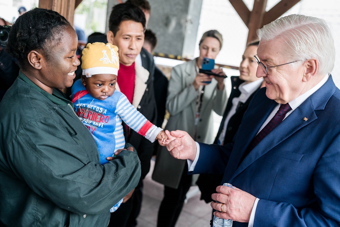 Bundespräsident Steinmeier spricht mit einer geflüchteten Frau die ein kleines Kind auf dem Arm hat (© Bundesregierung/Jesco Denzel) Bundespräsident Steinmeier spricht mit einer geflüchteten Frau die ein kleines Kind auf dem Arm hat