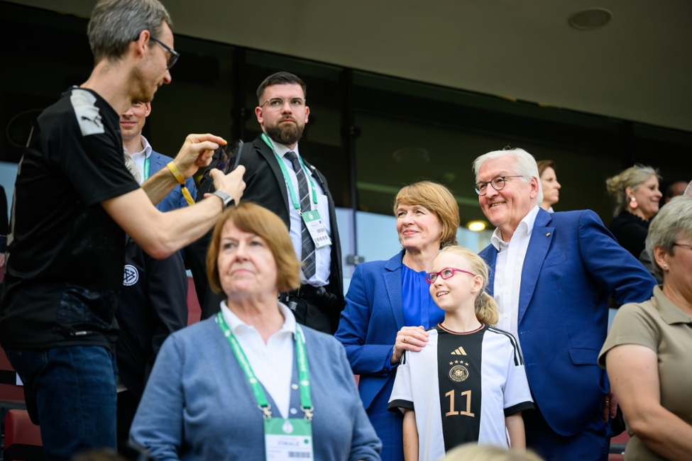Ein Mann macht ein Foto von Bundespräsident Steinmeier und Elke Büdenbender mit einem Mädchen (© Bundesregierung/Marvin Ibo Güngör) Ein Mann macht ein Foto von Bundespräsident Steinmeier und Elke Büdenbender mit einem Mädchen