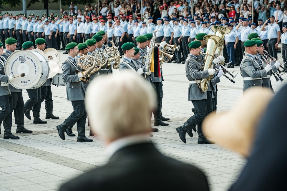 Bundespräsident Steinmeier (von hinten) blickt auf den Stabsmusikkorbs der Bundeswehr (© Bundesregierung/Denzel) Bundespräsident Steinmeier (von hinten) blickt auf den Stabsmusikkorbs der Bundeswehr