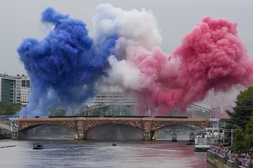 Rauch in den Farben der französischen Flagge über der Seine bei der Eröffnungsfeier der Olympischen Spiele 2024 in Paris (© picture alliance / ASSOCIATED PRESS | Matthias Schrader) Rauch in den Farben der französischen Flagge über der Seine bei der Eröffnungsfeier der Olympischen Spiele 2024 in Paris