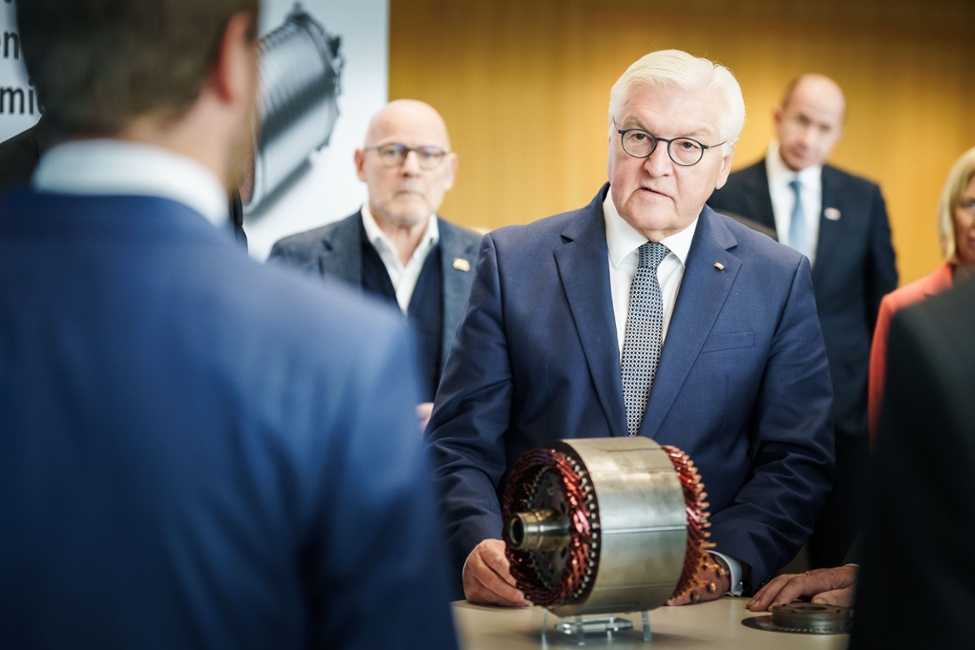 Bundespräsident Frank-Walter Steinmeier lässt sich am Modell eines E-Motors den Einsatz von Künstlicher Intelligenz in der Produktentwicklung erklären (© Bundesregierung/Denzel) Bundespräsident Frank-Walter Steinmeier lässt sich am Modell eines E-Motors den Einsatz von Künstlicher Intelligenz in der Produktentwicklung erklären