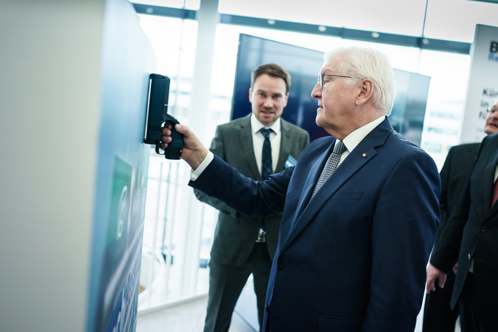 Bundespräsident Frank-Walter Steinmeier hält den Wandscanner von Bosch an eine Wand, um den den Einsatz von Künstlicher Intelligenz in der Messtechnik zu testen (© Bundesregierung/Denzel) Bundespräsident Frank-Walter Steinmeier hält den Wandscanner von Bosch an eine Wand, um den den Einsatz von Künstlicher Intelligenz in der Messtechnik zu testen