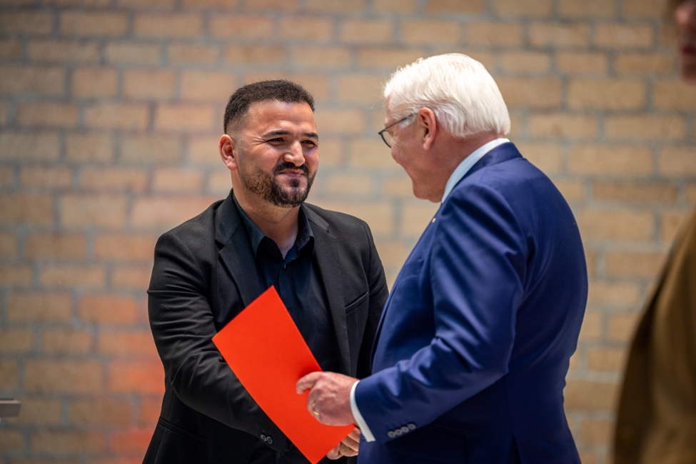 Der Bundespräsident überreicht einem Mann seine Einbürgerungsurkunde und schüttelt ihm die Hand (© Photothek/Juliane Sonntag) Der Bundespräsident überreicht einem Mann seine Einbürgerungsurkunde und schüttelt ihm die Hand