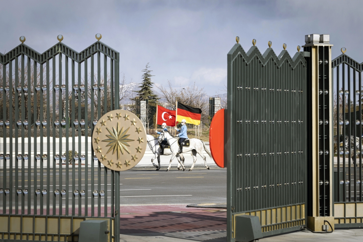 Two riders with the German and Turkish flags behind the gates of the presidential palace.