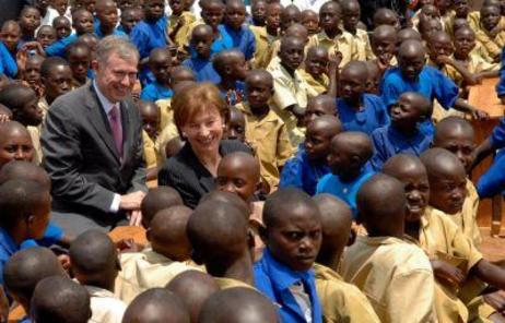 Bundespräsident Horst Köhler und Frau Köhler stehen inmitten von Kindern in blauen und beigen Hemden