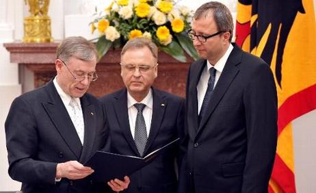 Der Bundespräsident verliest im Großen Saal von Schloss Bellevue den Text der Entlassungsurkunde für den scheidenden Präsidenten des Bundesverfassungsgerichts, Hans-Jürgen Papier. Daneben steht der neue Gerichtspräsident, Andreas Voßkuhle. 